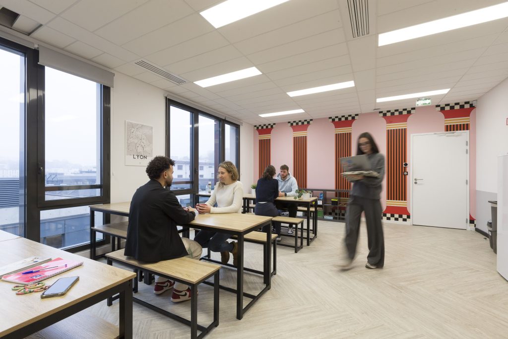 personnes dans un espace de coworkin avec un papier peint à colonnes